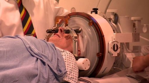 Paciente con parte de la cabeza en un aparato que emite ondas de sonido