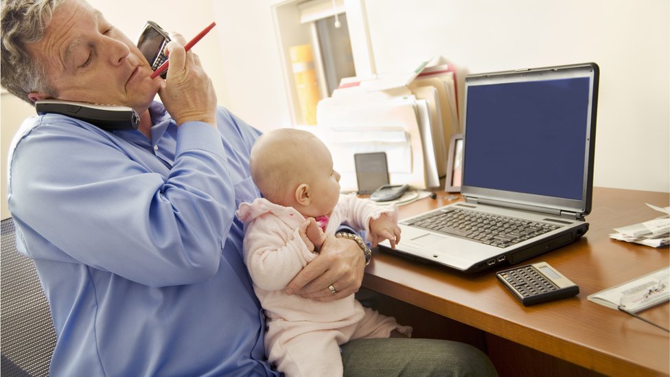 Padre con bebé, hablando por teléfono