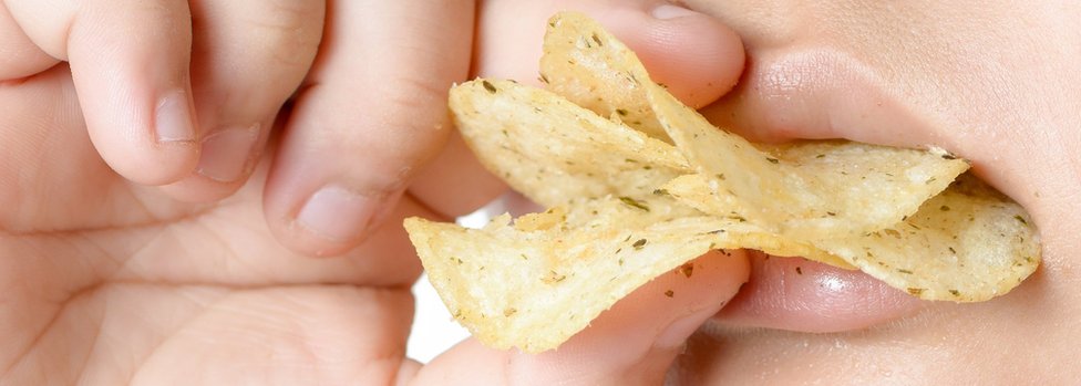 Persona comiendo papas fritas crocantes.