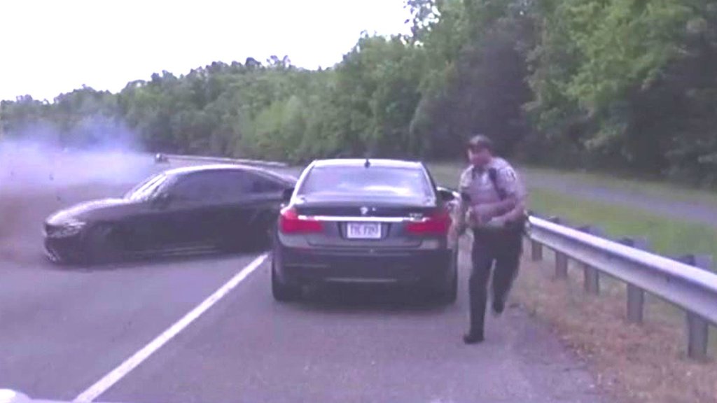 Officer inches from death as car spins across highway