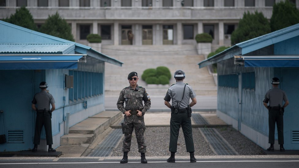 Dalam sebuah foto yang diambil pada tanggal 2 Agustus 2017, tentara Korea Selatan berjaga-jaga di depan Panmon Hall (sisi C) Korea Utara dan garis demarkasi militer yang memisahkan Korea Utara dan Selatan, di Panmunjom, di Area Keamanan Bersama Zona Demiliterisasi.