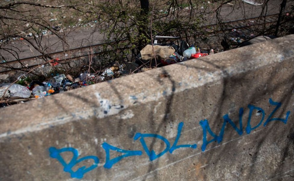 Márgenes de las vías del tren llenas de basura.
