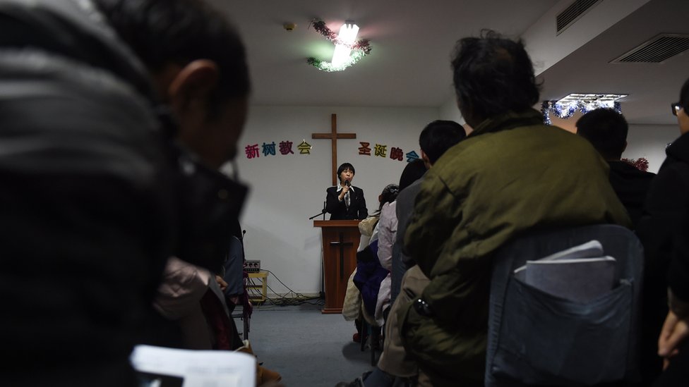 A photo taken on December 24, 2014 shows a pastor of an underground church conducting a Christmas Eve service at an apartment in Beijing