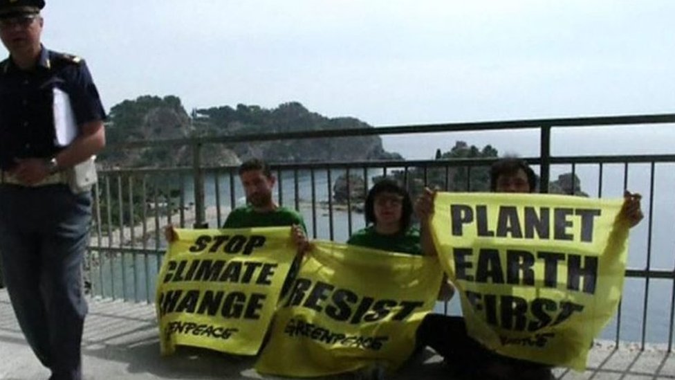 نشطاء يحمل لافتات تطالب بضرورة مكافحة التغير المناخي