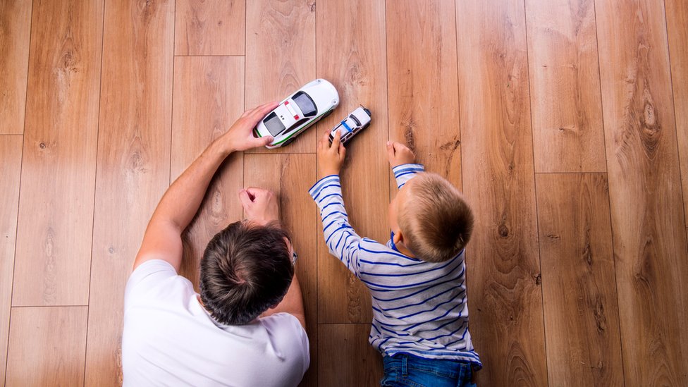 Padre e hijo juegan con coches de juguete
