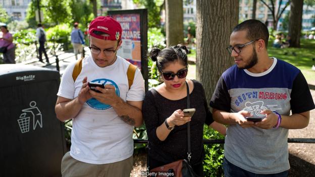 Tres personas con sus móviles.