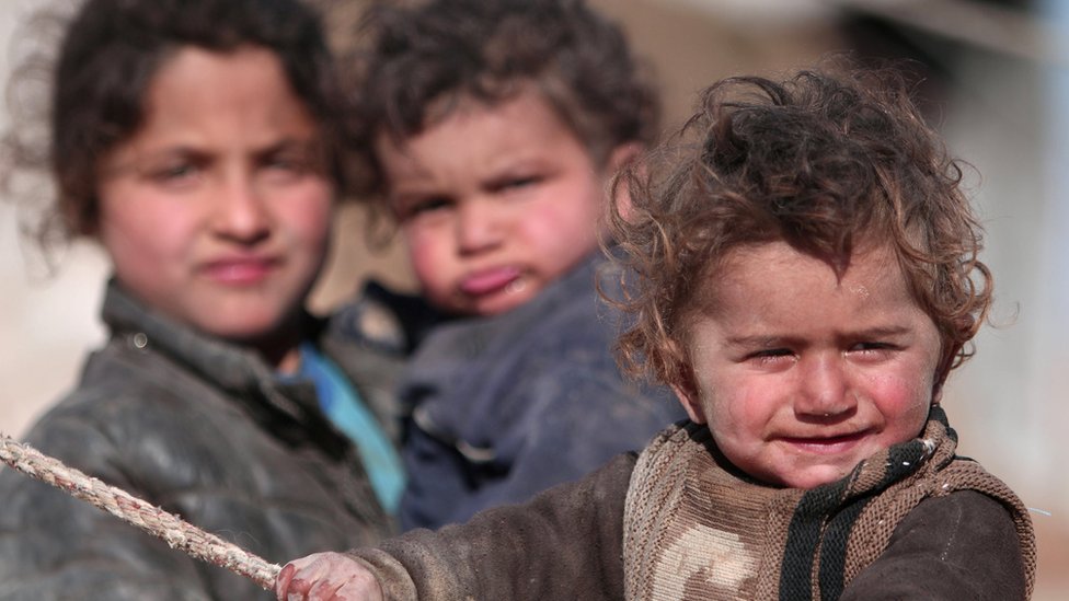 Internally displaced Syrian children who fled Raqqa city stand near their tent in Ras al-Ain province
