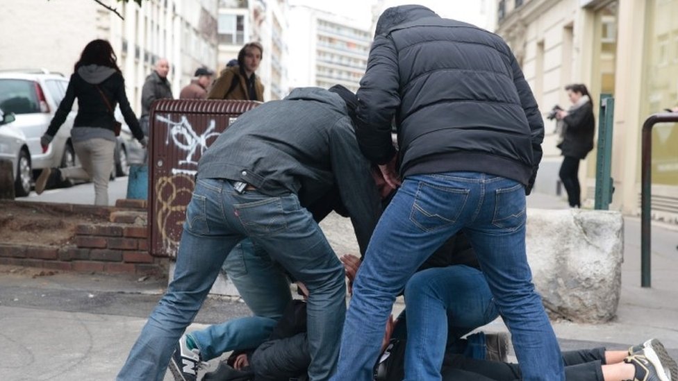 رجال شرطة في زي مدني يلقون القبض على رجل من بين المحتجين