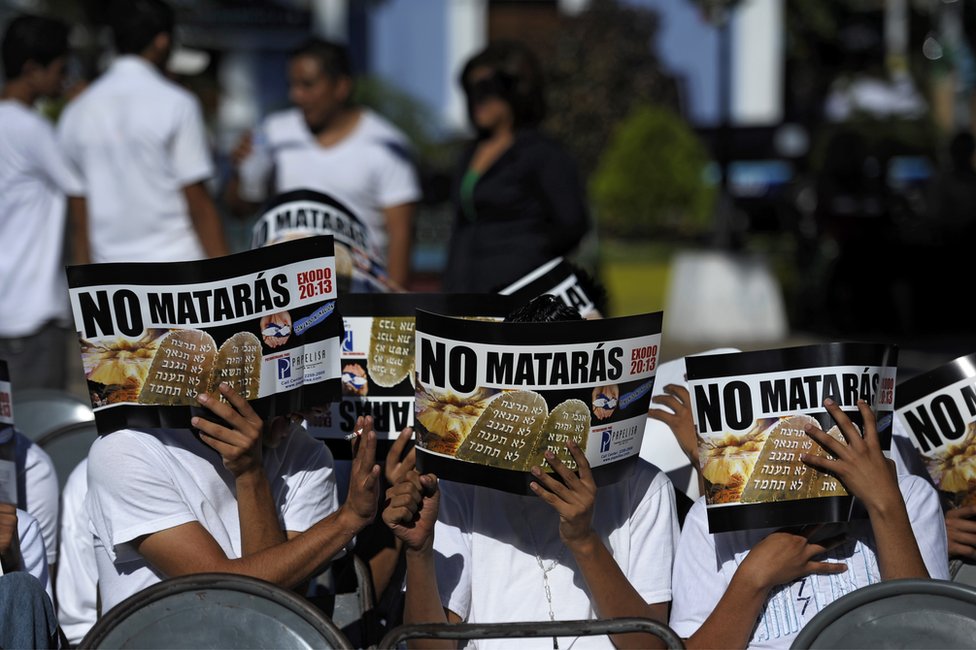 Pandilleros se cubren la cara con unos documentos en los que se lee 