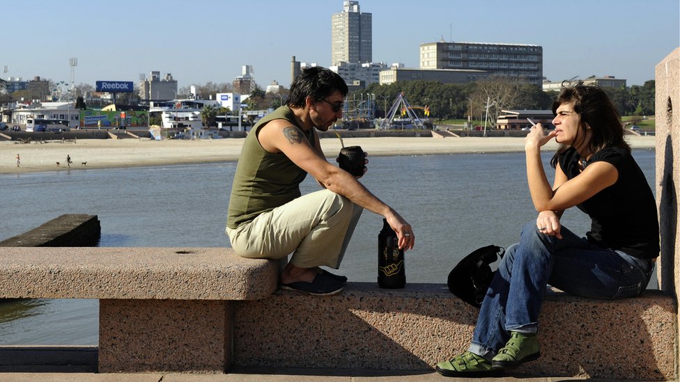 Hombre y mujer tomando mate en la rambla de Montevideo.