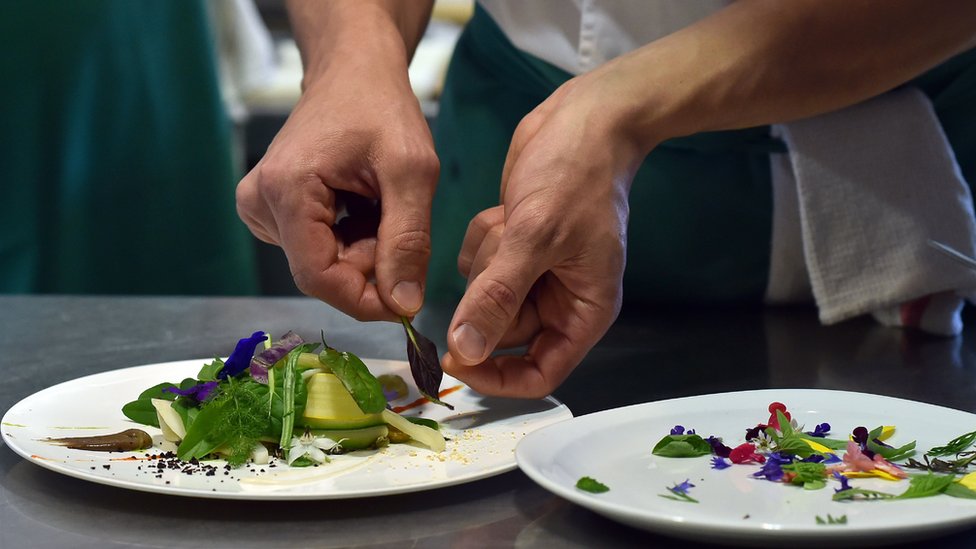 Un chef prepara un plato.