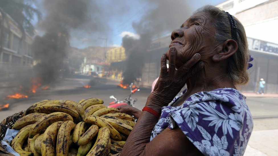 Mujer vendiendo bananos en Tegucigalpa durante una protesta