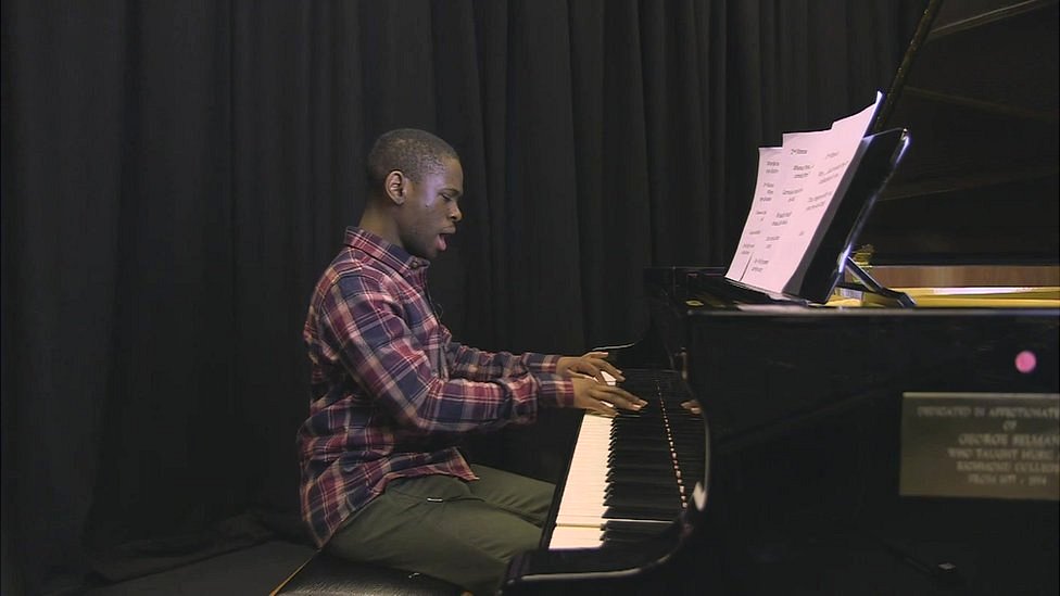 Michael interpretando al piano una pieza propia.