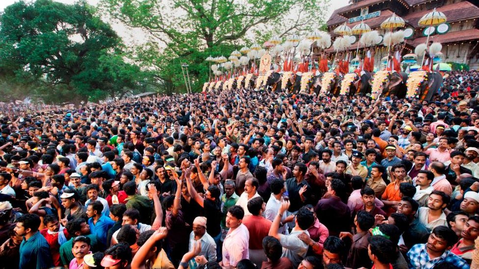 Thousands gathers before a temple in Kerala. Ceremonial elephants can be seen in the background.