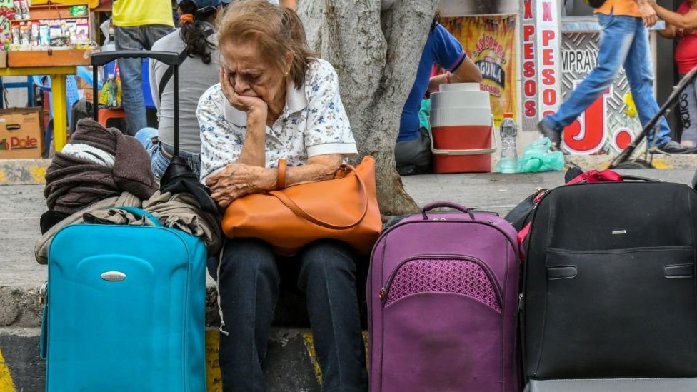 Una mujer sentada junto a varias maletas