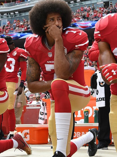 Colin Kaepernick, mariscal de campo de los 49ers, arrodillado durante el himno estadounidense.