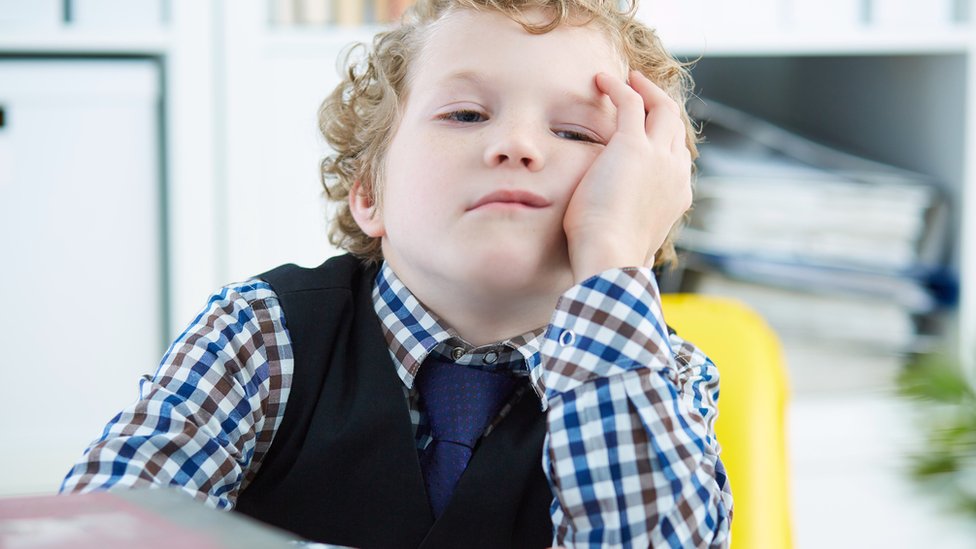 Niño aburrido en clase.