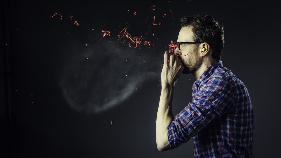 Hombre explotando un globo