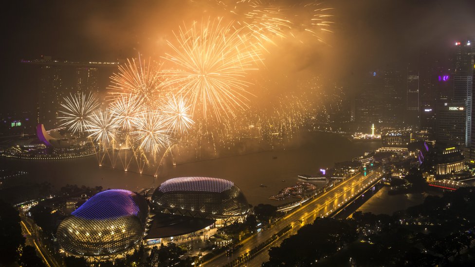 New Year Eve's fireworks illuminate the skyline of the Marina Bay Sands resort (back-L), the Esplanade Theatres (front-L), and the financial district (R) around the Marina Bay in Singapore, 01 January 2018.