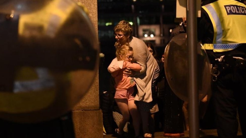 Una mujer sostiene a una niña