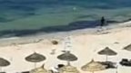 Still from footage showing Tunisia gunman running along beach