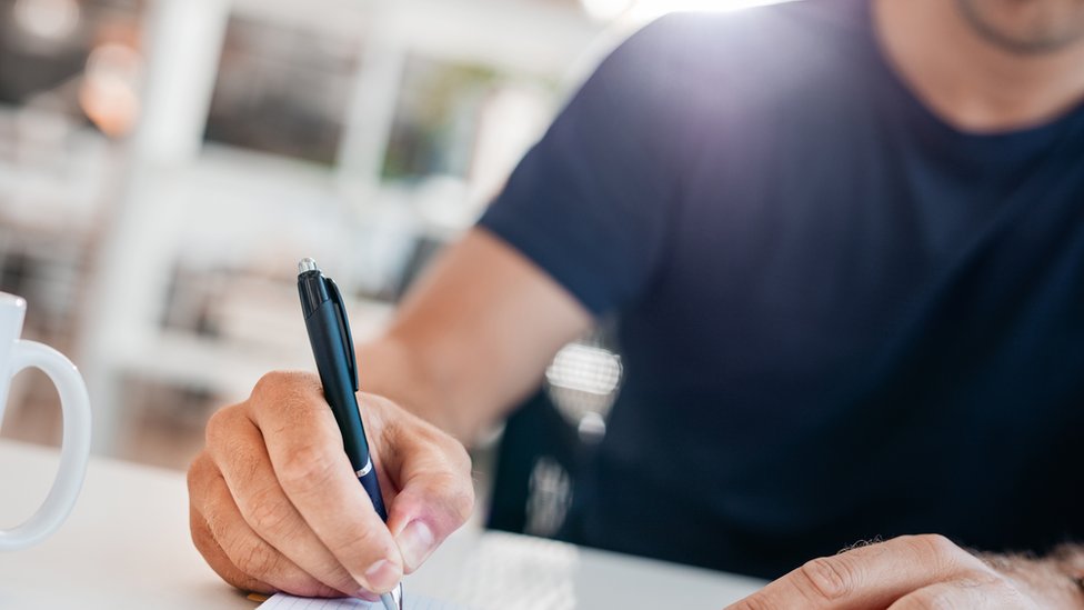 Un hombre escribiendo en un diario