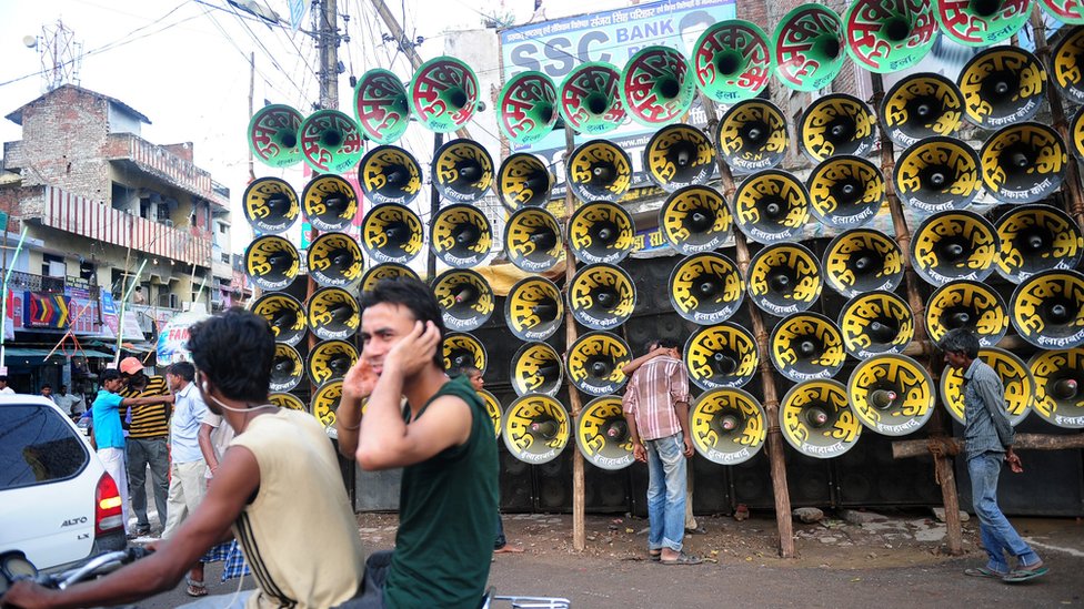 An Indian man protects his ears with his hands during a loudspeaker competition ahead of the Dussehra Hindu festival in Allahabad on September 20, 2015
