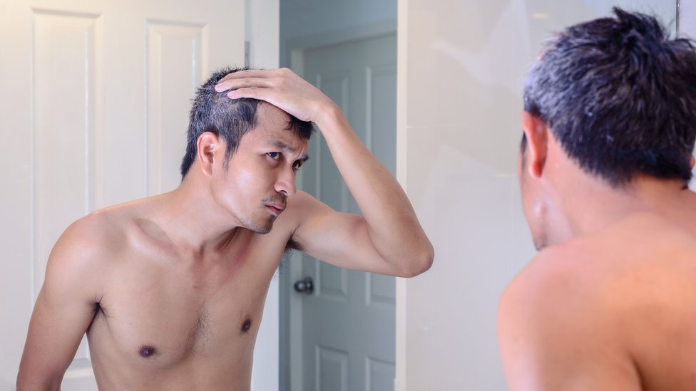Hombre viéndose en el espejo