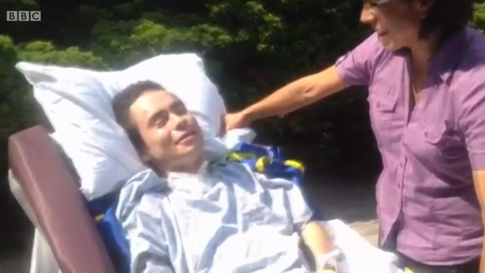 Juan Torres en el exterior del hospital, sonriendo por primera vez junto a su madre