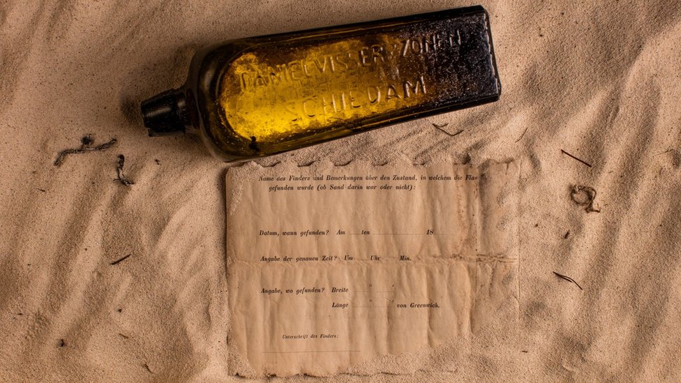 La botella y la nota sobre la arena. (Foto: kymillman.com)