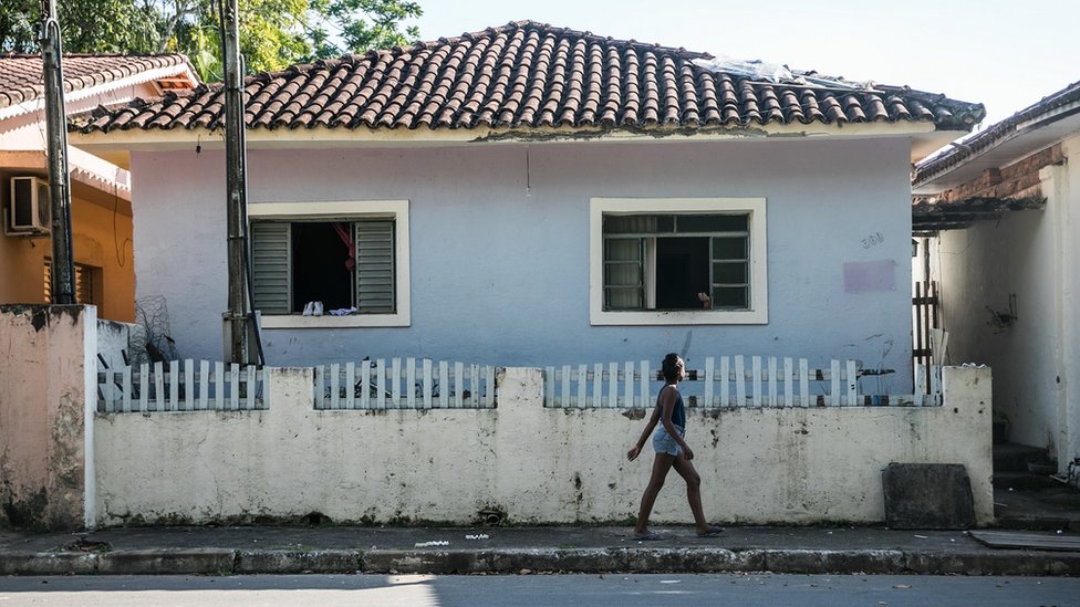 Vista traseira dos homens assistindo a um jogo de futebol na tv e sentado  em um sofá