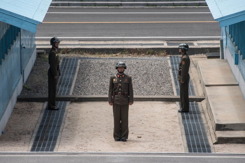 n a photo taken on 2 June 2017, Korean People's Army (KAPPA) soldiers stand guard before the military demarcation line separating North and South Korea at the Joint Security Area (JSA) near Kaesong on the North Korean side of the border