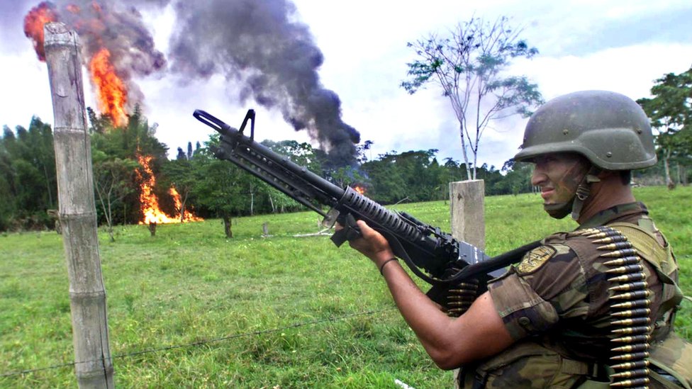 A Colombian Army soldiers stands guard as cocaine paste is destroyed by fire 12 February 2001 in Puerto Asis, Colombia