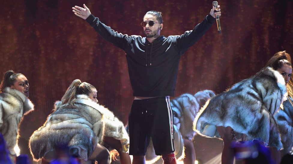Maluma en concierto rodeado de bailarinas.