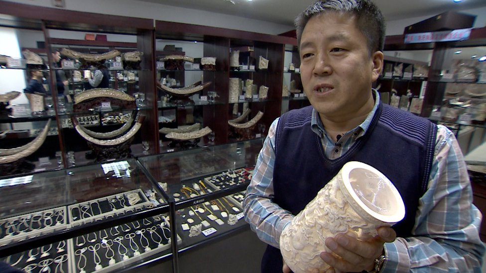 Liu Fenghai speaks to the BBC as he holds a carved ivory item