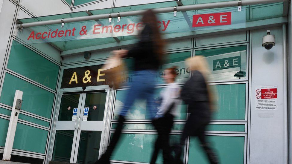 Pedestrians walk past an accident and emergency department