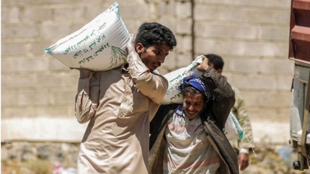 يمنيون يحملون مساعدات