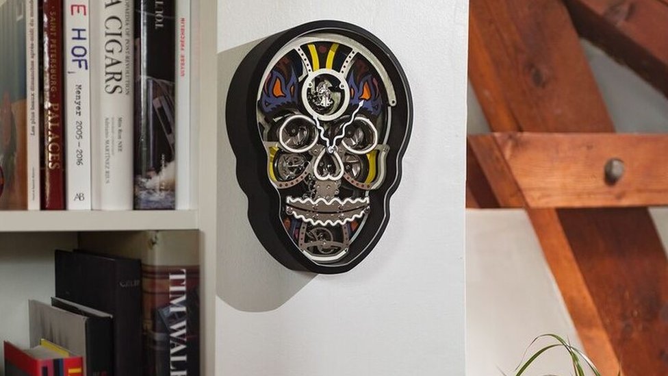 Reloj con forma de cráneo en una pared.