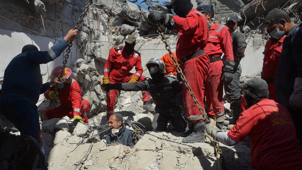 أفراد الإنقاذ يفتشون عن جثث الضحايا بين الحطام بعد غارة جوية للتحالف