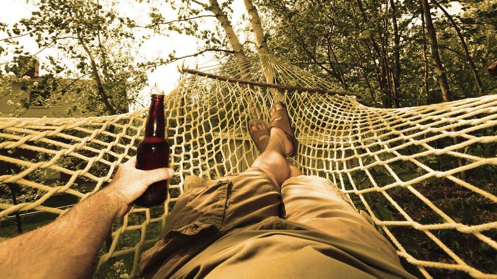 Hombre en hamaca con cerveza
