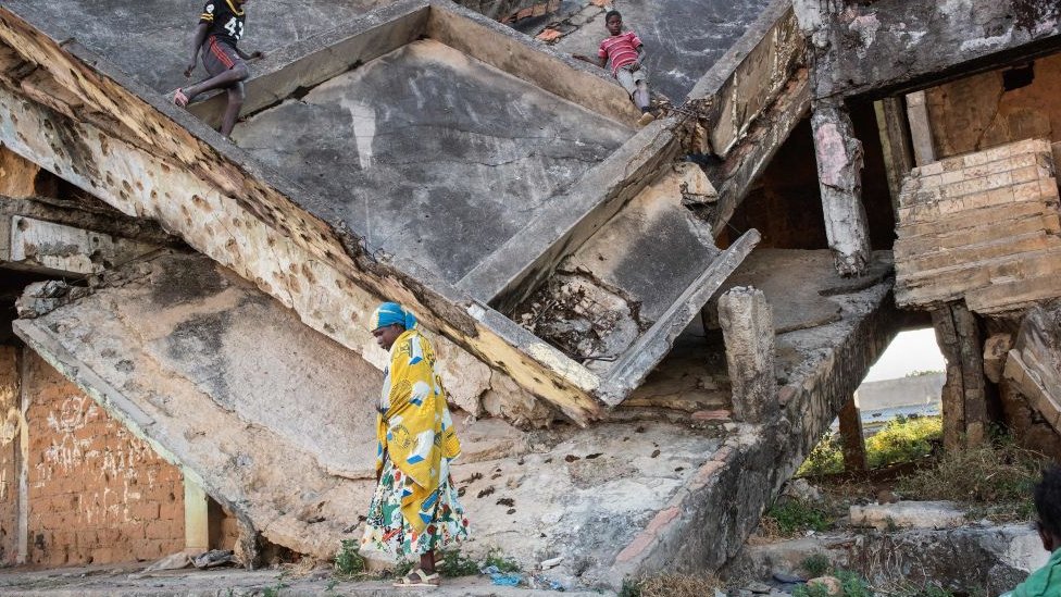 Kinder spielen in einem verlassenen Gebäude, das während des Bürgerkriegs in Angola, Kuito - 2019 beschädigt wurde
