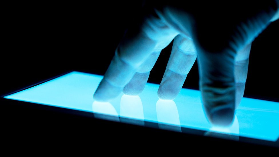 Mano tocando pantalla táctil.