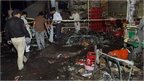 Pakistani police and security officers examine the site of an explosion in Multan, Pakistan