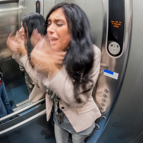 Mujer con ataque de pánico en un ascensor.