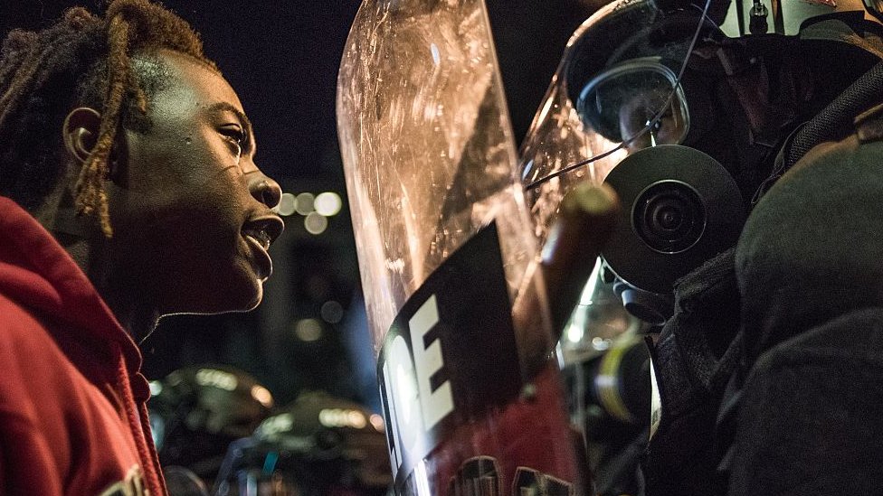 En los últimos años han aumentado las tensiones entre la policía y la comunidad negra en Estados Unidos. Mujer negra enfrentándose a un policía durante una protesta.