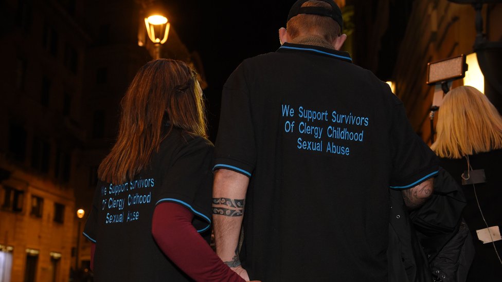 A survivor of child abuse, and his wife, hold hands while wearing T-shirts that read: 