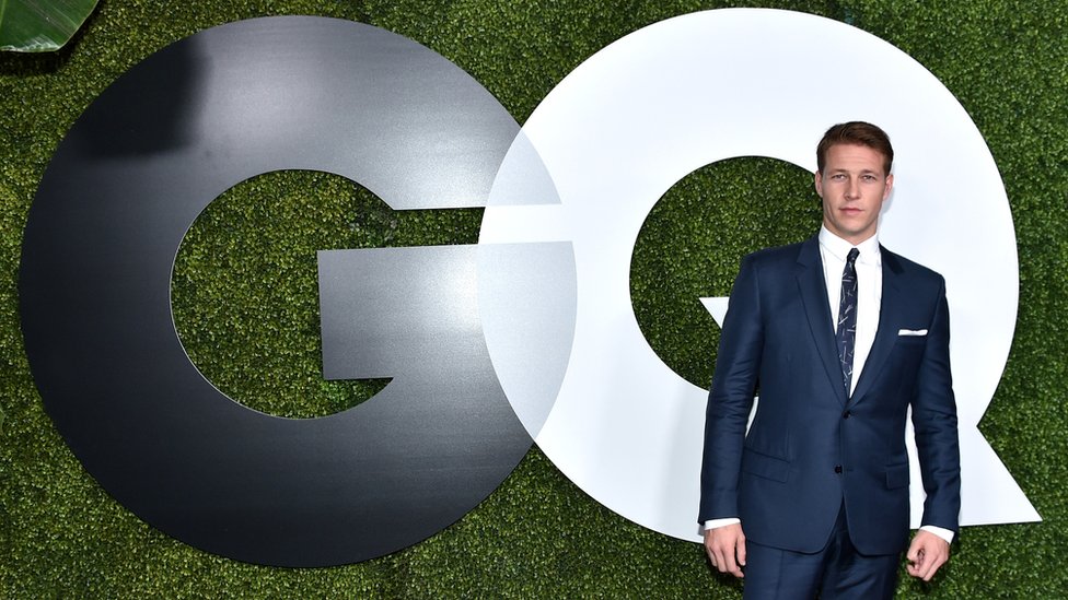 Man in front of GQ logo