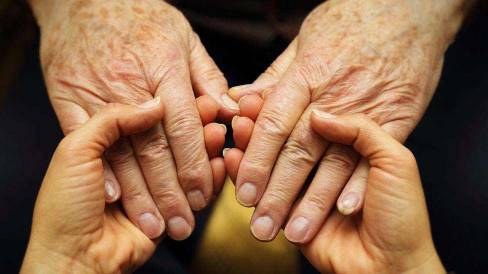 Dos personas de manos dadas