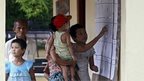 A woman with her childern checks the voters list at the Wahtheinkha village in Kawmhu township, Yangon, Myanmar