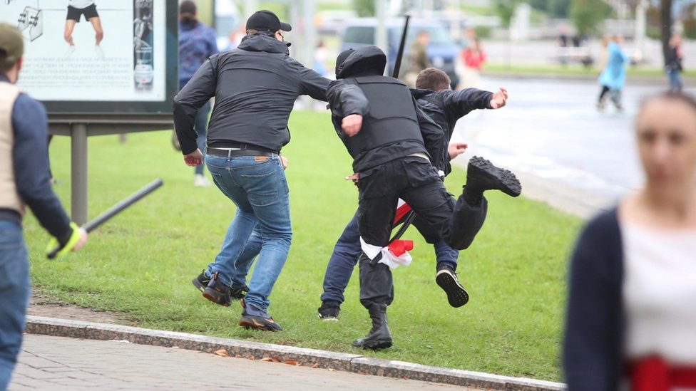 Unidentified people holding batons chase a man in an attempt to knock him down during an opposition rally to protest against police brutality and to reject the presidential election results in Minsk, Belarus September 6, 2020.